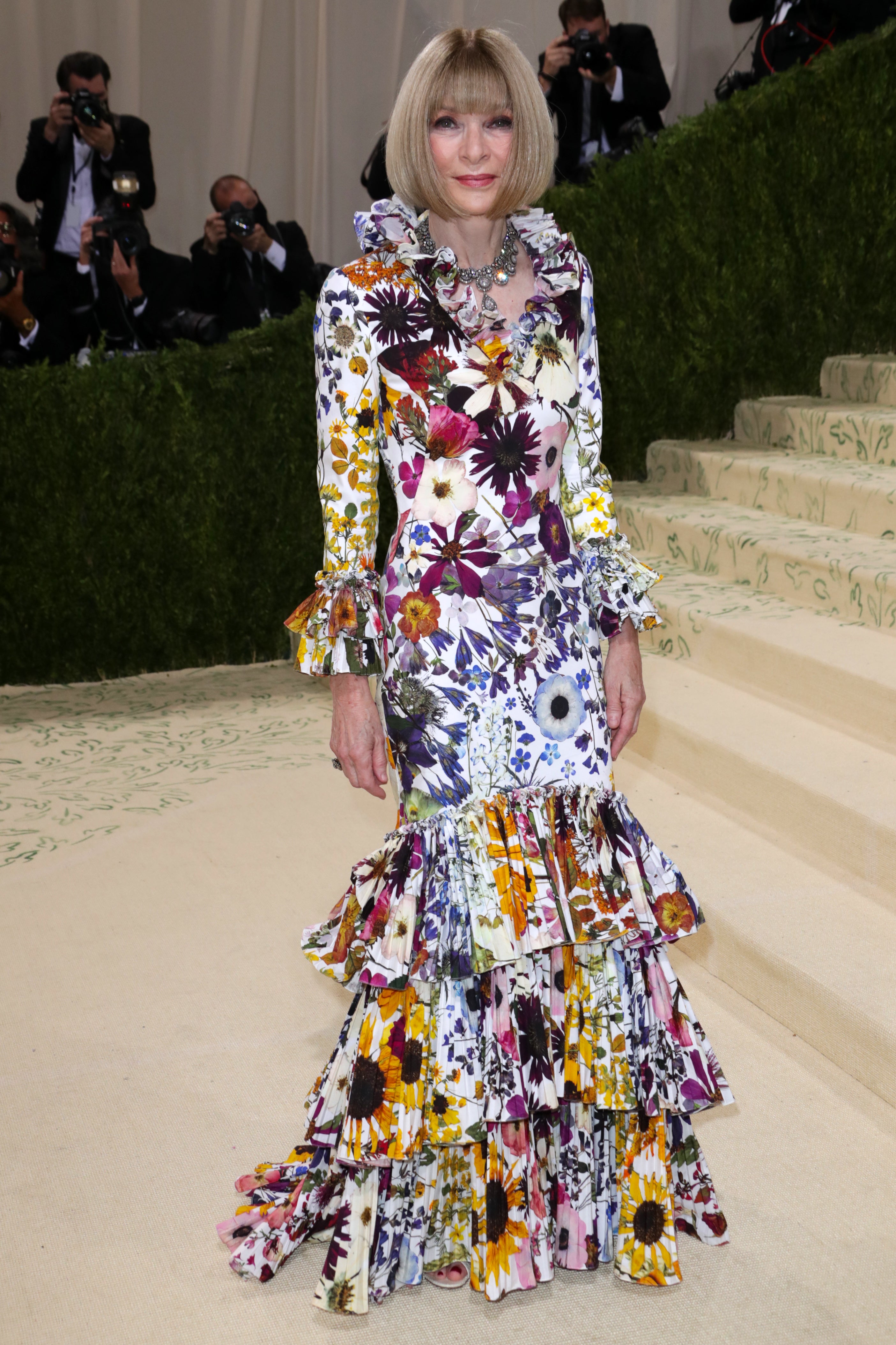 Woman wearing a colorful floral dress on a red carpet