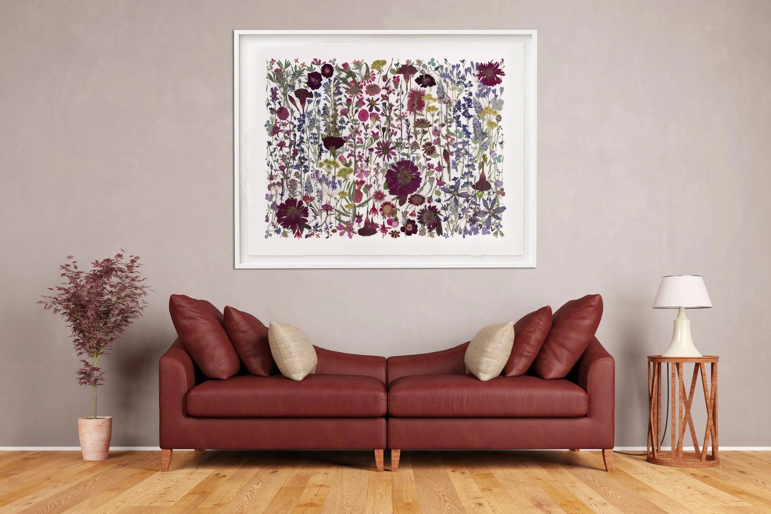 Red sofa in a living room with a floral framed artwork on the wall.