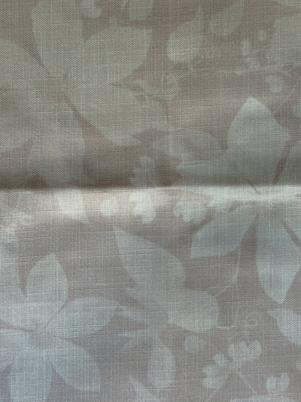 Textured fabric with leaf pattern in pink tones