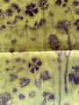 Textile with black paw print pattern on a yellow background