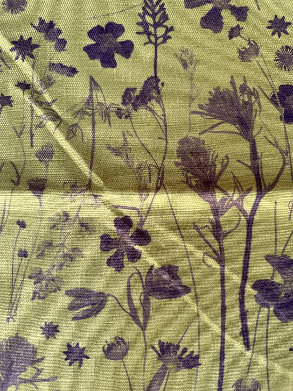 Fabric with black floral pattern on a green background
