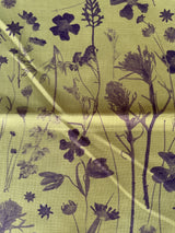 Fabric with black floral pattern on a green background