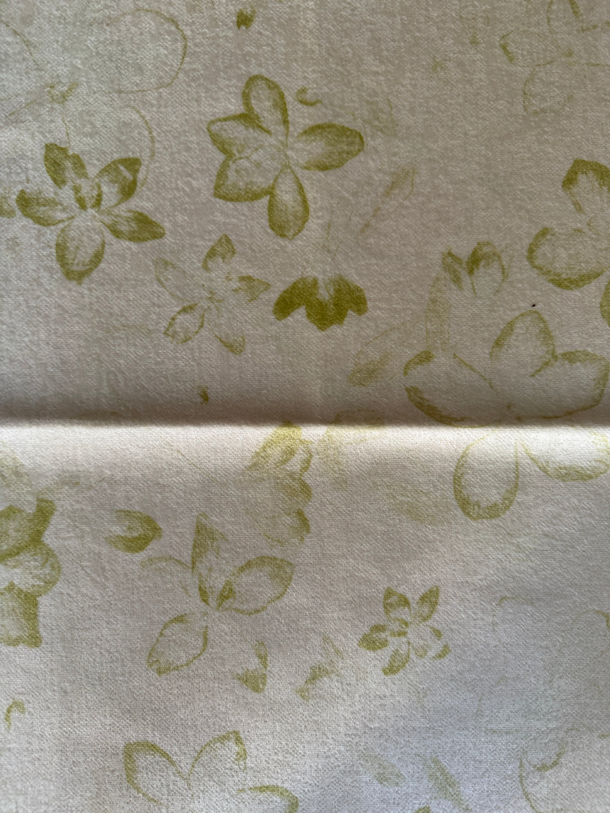 Floral patterned fabric with green flowers on a beige background