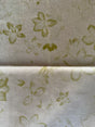 Floral patterned fabric with green flowers on a beige background