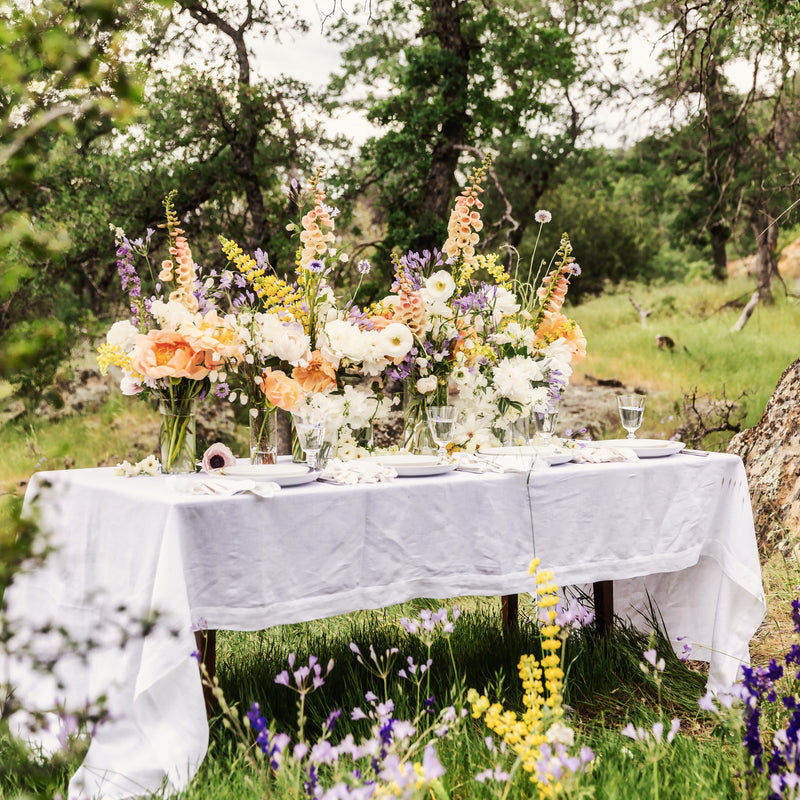 Table set with flowers and tablecloth in a natural outdoor setting