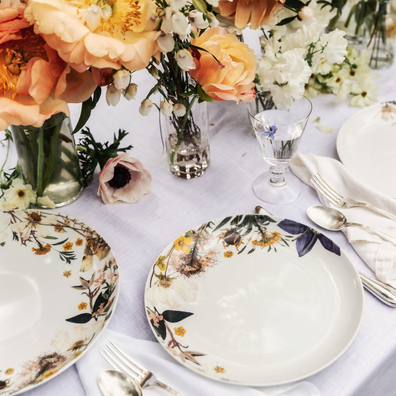 Decorative table setting with floral centerpieces and plates.