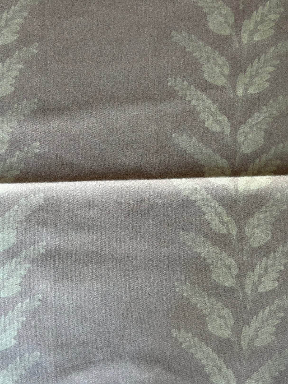 Fabric with leaf pattern on a mauve background